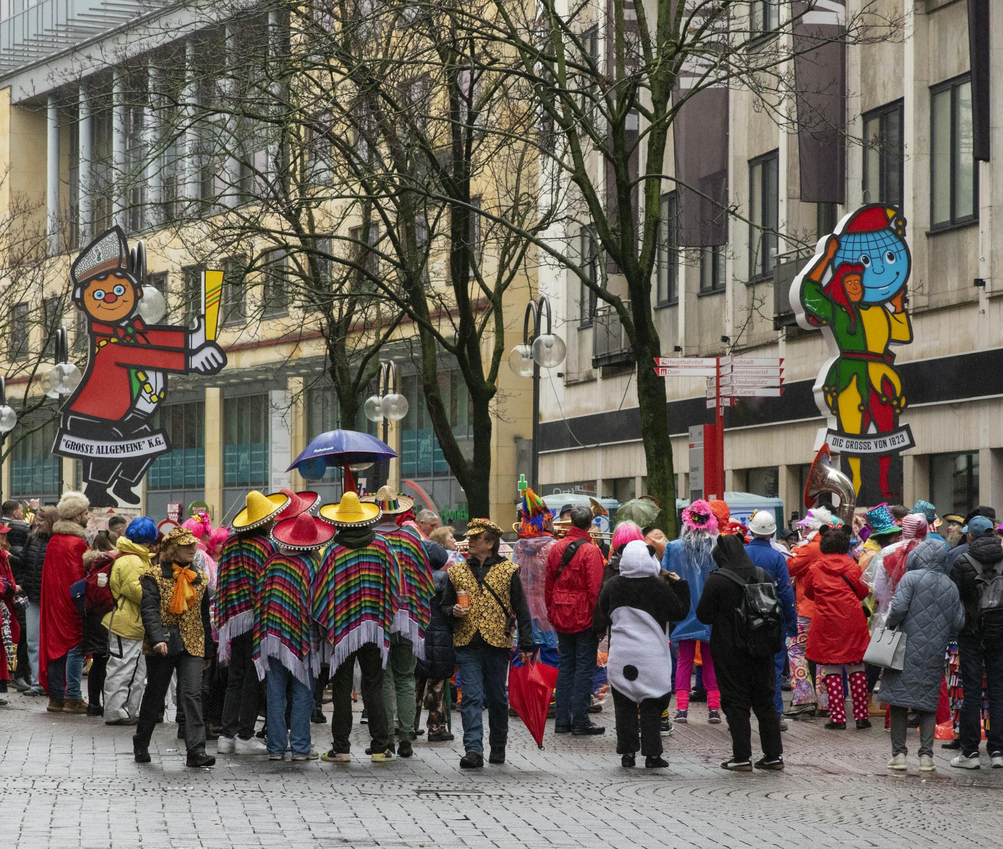 Vibrant street celebration during Cologne's famous carnival festival with attendees in colorful costumes and parade floats.